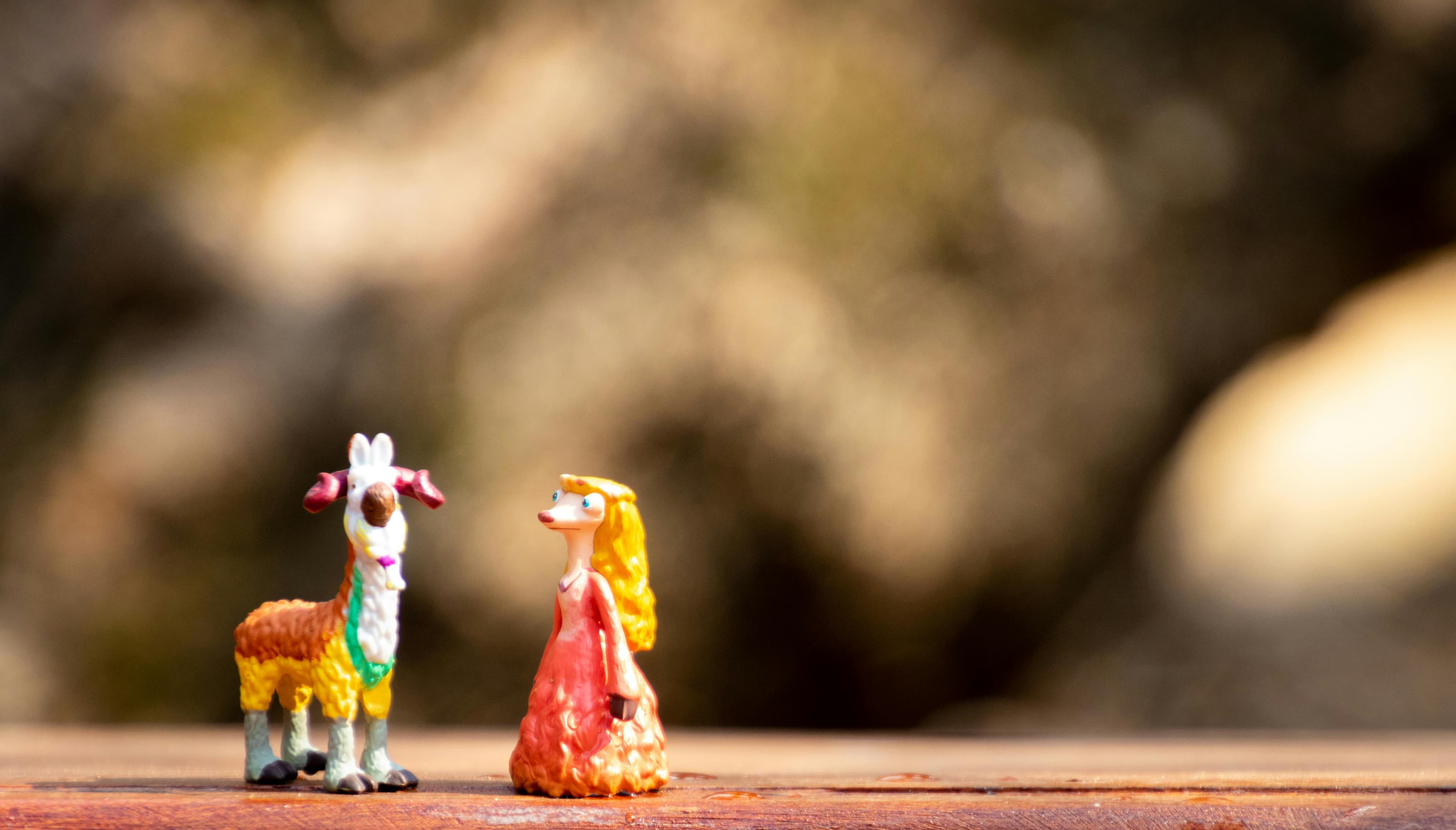 Playful miniature goat and whimsical character figurines on a rustic surface.